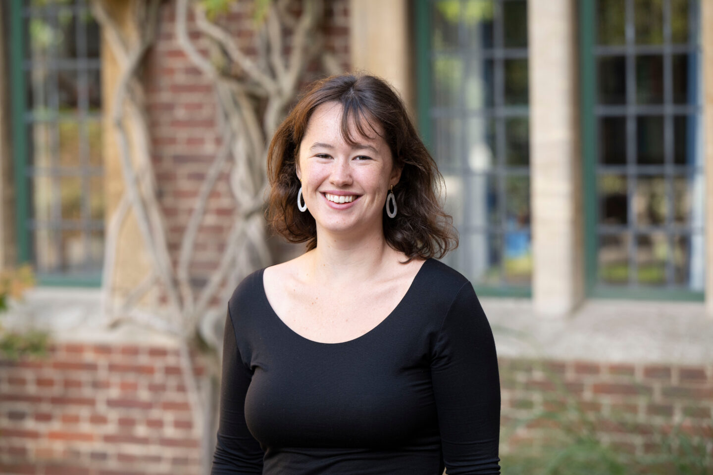 A headshot of Jane Kuper outside a brick building with vines