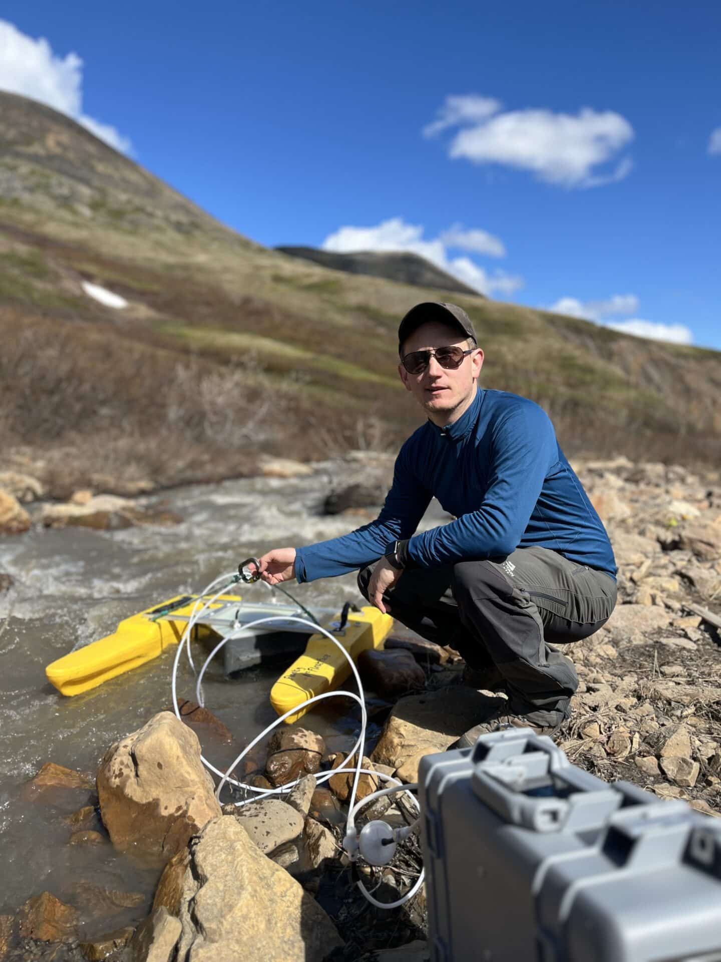Bob Hilton standing by a rocky creek with scientific equipment