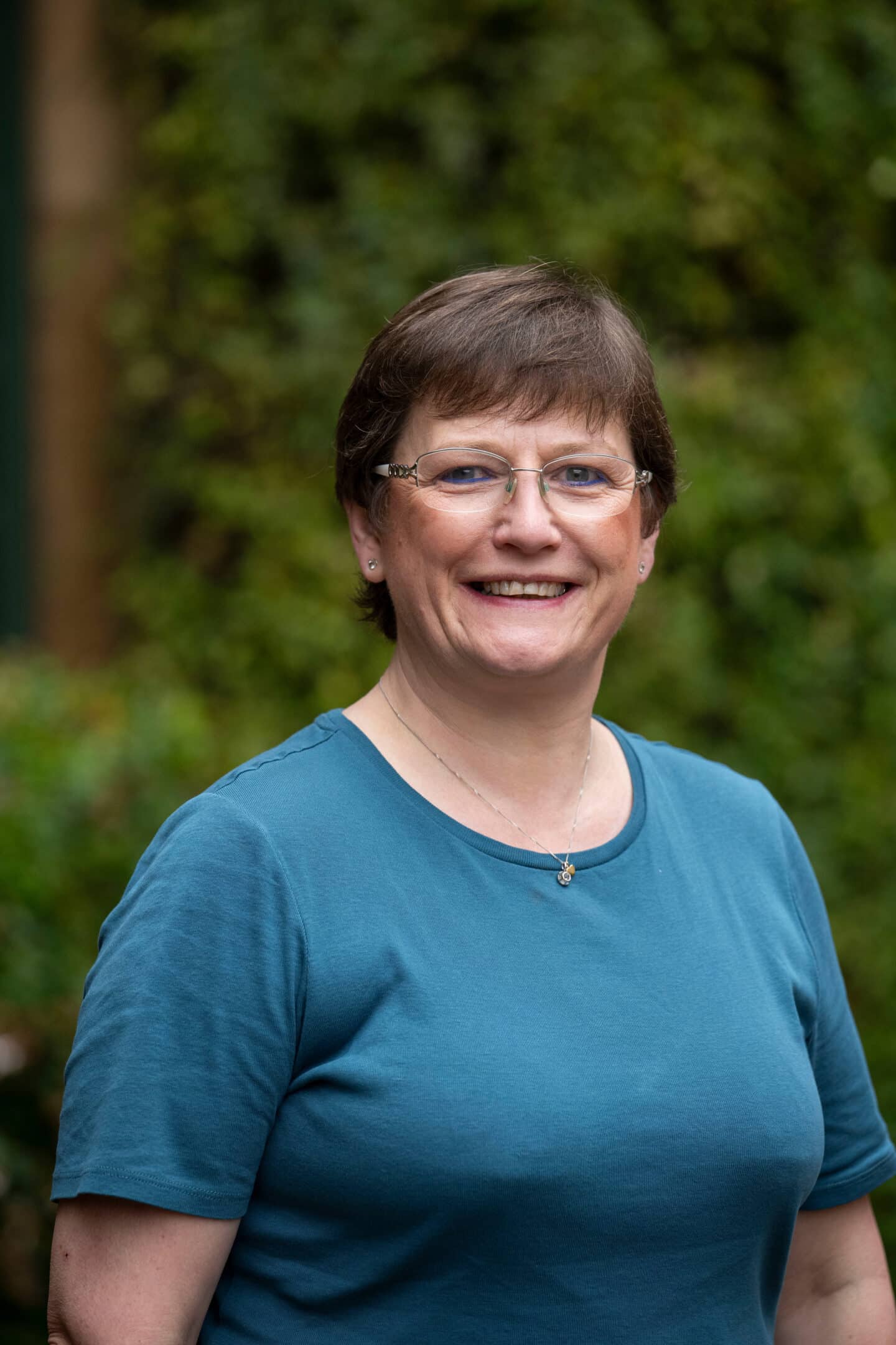A woman standing outdoors and smiling
