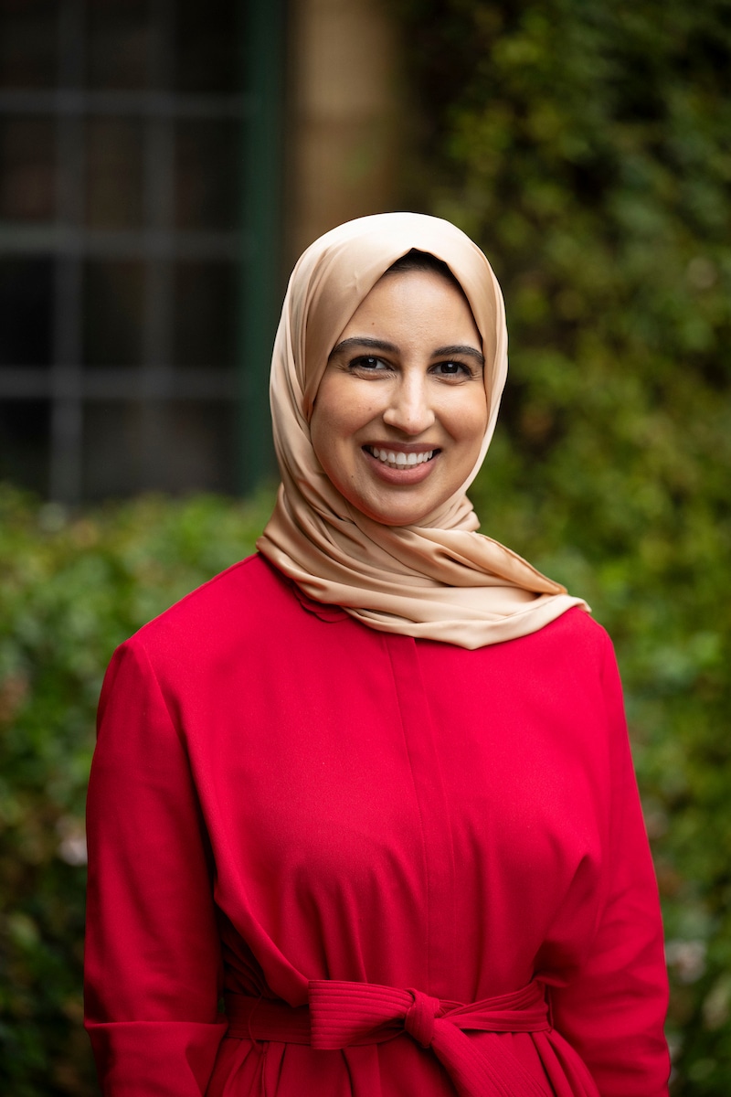 Ayeshah Abdul-Hamid - a headshot of a woman wearing a red dress and beige hijab