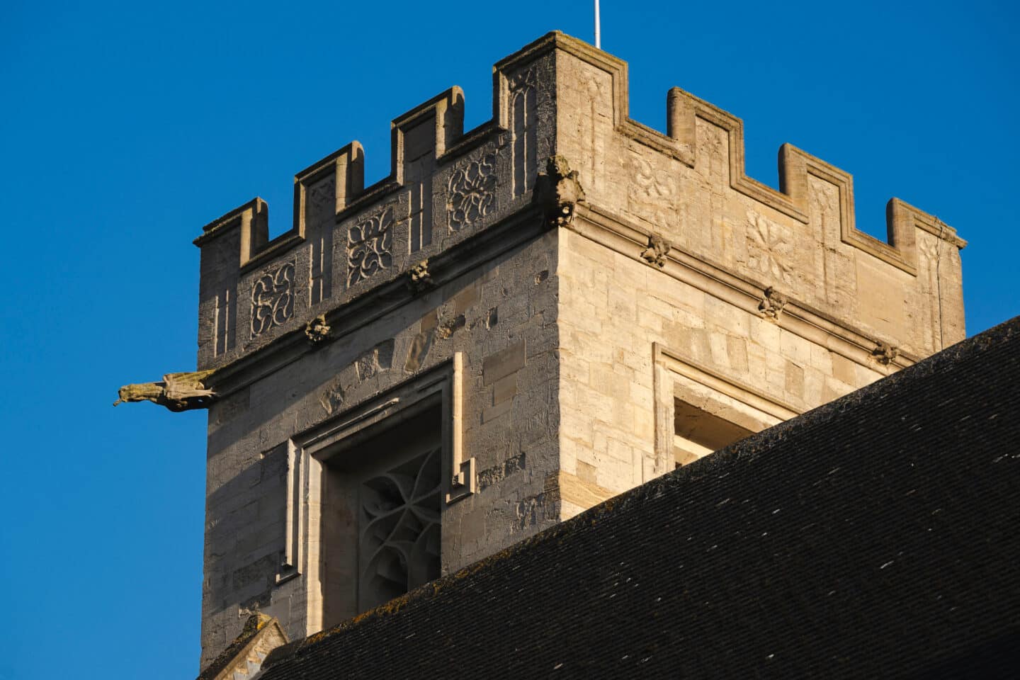 A chapel spire with a clear and bright sky behind it