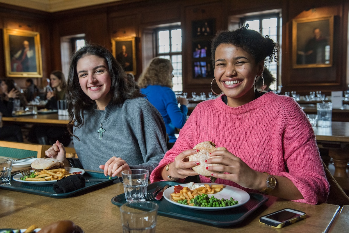 Two students smiling and having lunch together