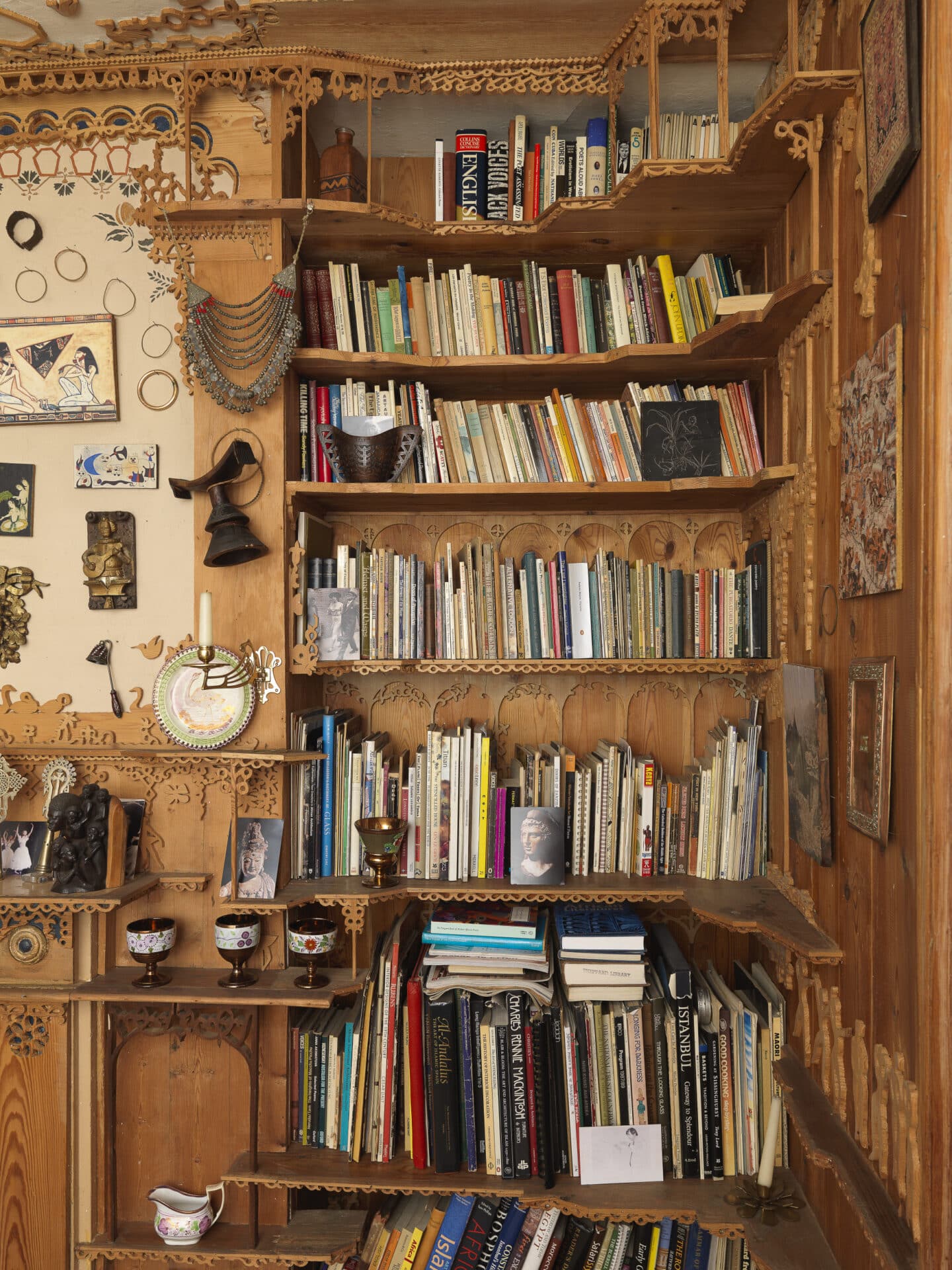 a carved wooden shelf with books and magazines